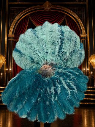 Oversized teal and seafoam ostrich feather fan pair with layered natural feathers and clear staves