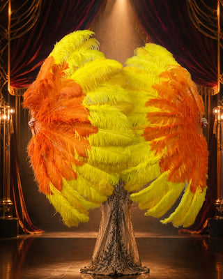 Pair of custom yellow and orange three-layer ostrich feather fans displayed by a cabaret performer on a luxury Art Deco stage