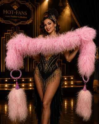 Custom pink ostrich feather boa with ring handles and feather tassel ends displayed by a model on stage.