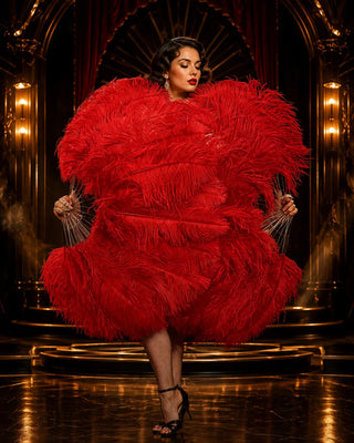 Luxury red ostrich feather fan on a black and gold cabaret stage with an elegant adult female performer