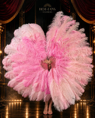 Oversized blush pink and soft pink ostrich feather fan in a luxury  stage-inspired promotional scene, held in an elegant side pose.